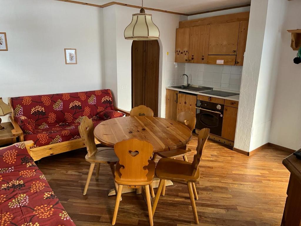 a kitchen with a table and chairs and a couch at Bilocale Casa Canazei in Alba di Canazei