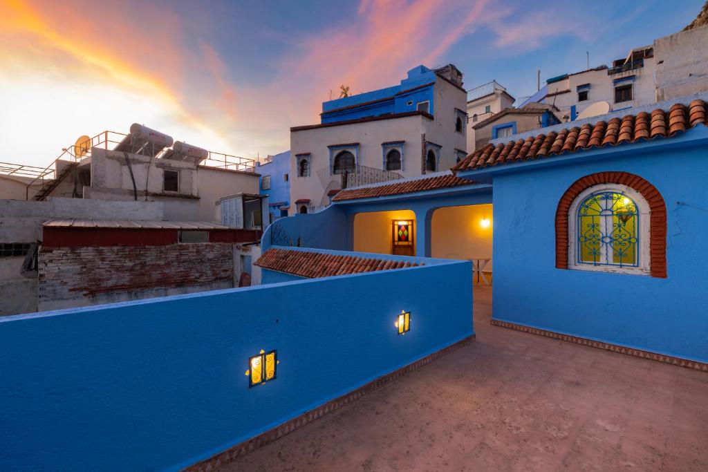 a blue building with a sunset in the background at Casa Panorama in Chefchaouen