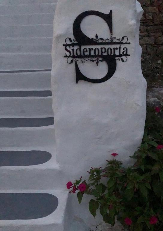 a sign on the side of a house with flowers at Sideroporta castle Náfpaktos in Nafpaktos