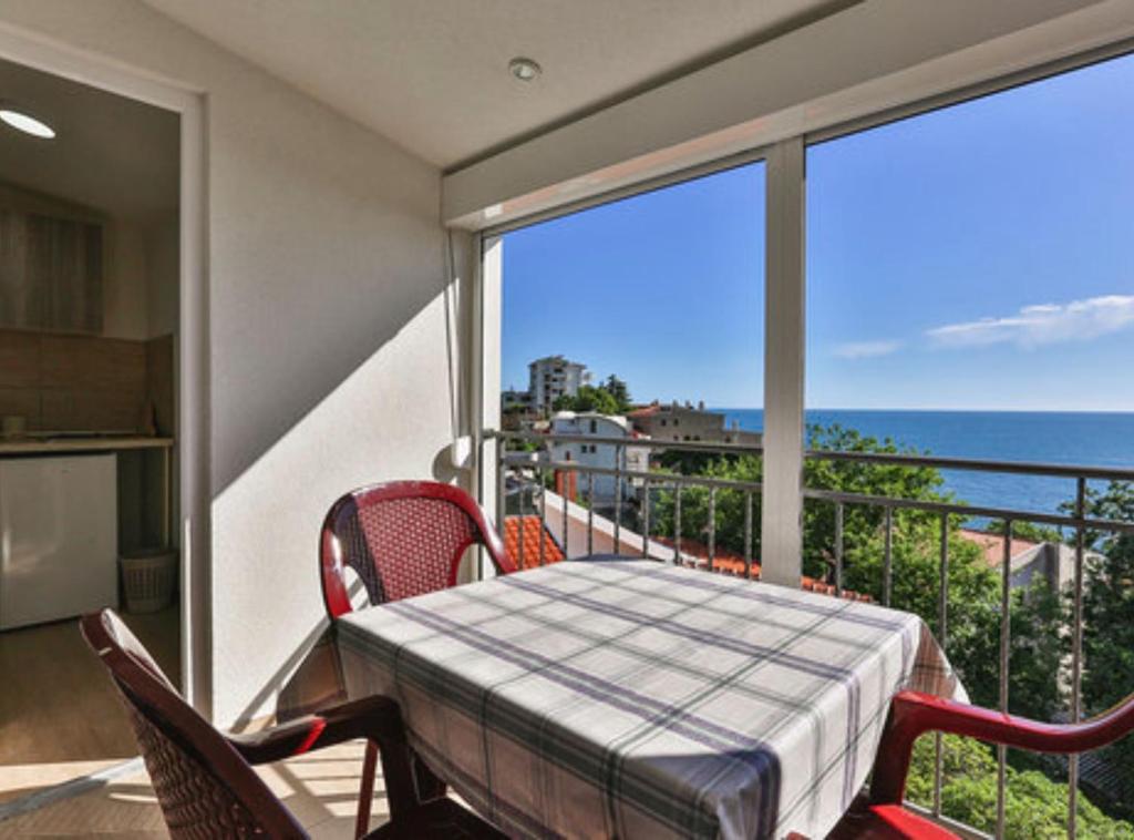 a balcony with a table and chairs and a view of the ocean at Beachfront Sunset Apartments Sutomore in Brca