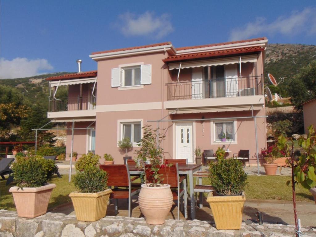 a pink house with potted plants in front of it at Zoi studio in Kefallonia