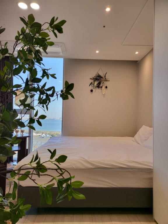a bedroom with a bed and a large window at Ocean View Hotel near Incheon Airport in Chagyak-to