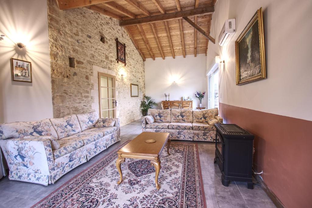 a living room with two couches and a wood stove at Gîtes de Peyrounou in Lacapelle-Biron