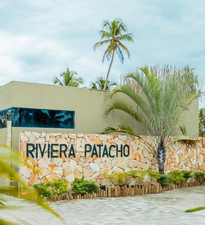 a building with a sign that reads riviera palapa at Bangalôs Riviera do Patacho in Pôrto de Pedras