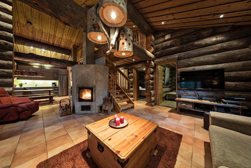 a living room with a fireplace in a log cabin at UnelmaVeska in Ruka