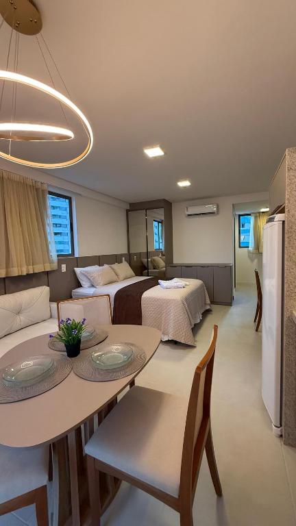 a room with two beds and a table with chairs at Flat Luxo em Boa Viagem - 5min do Aeroporto - perto da praia - Wi-Fi 500mb - check-in 24h in Recife
