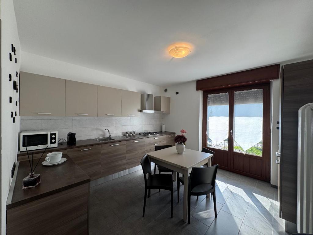 a kitchen with a table and chairs and a kitchen with a window at La Gare Apartments - Zerbion in Châtillon