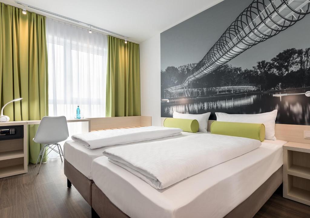 a bedroom with a large bed with green curtains at Super 8 by Wyndham Oberhausen am Centro in Oberhausen