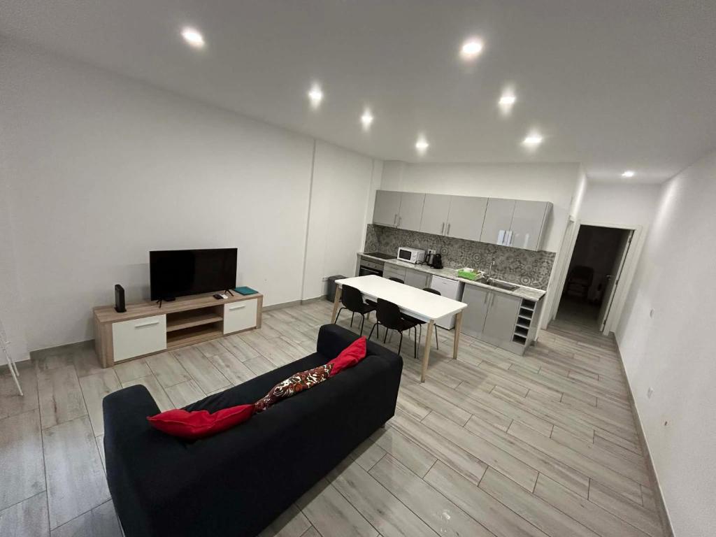 a living room with a couch and a table and a kitchen at CASA ANALUCIA in Faro