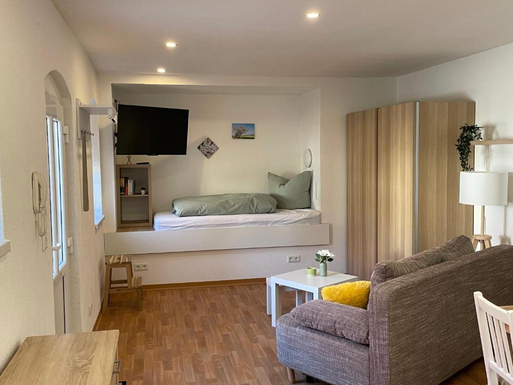 ein kleines Wohnzimmer mit einem Bett und einer Couch in der Unterkunft Markt24-2 in Hecklingen