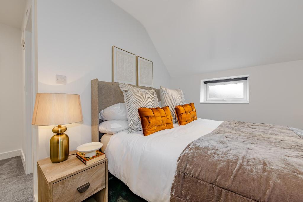 a bedroom with a large bed with orange pillows at Studio Room, Parking, Contractors and Relocators, Weekly Deals in Maidstone