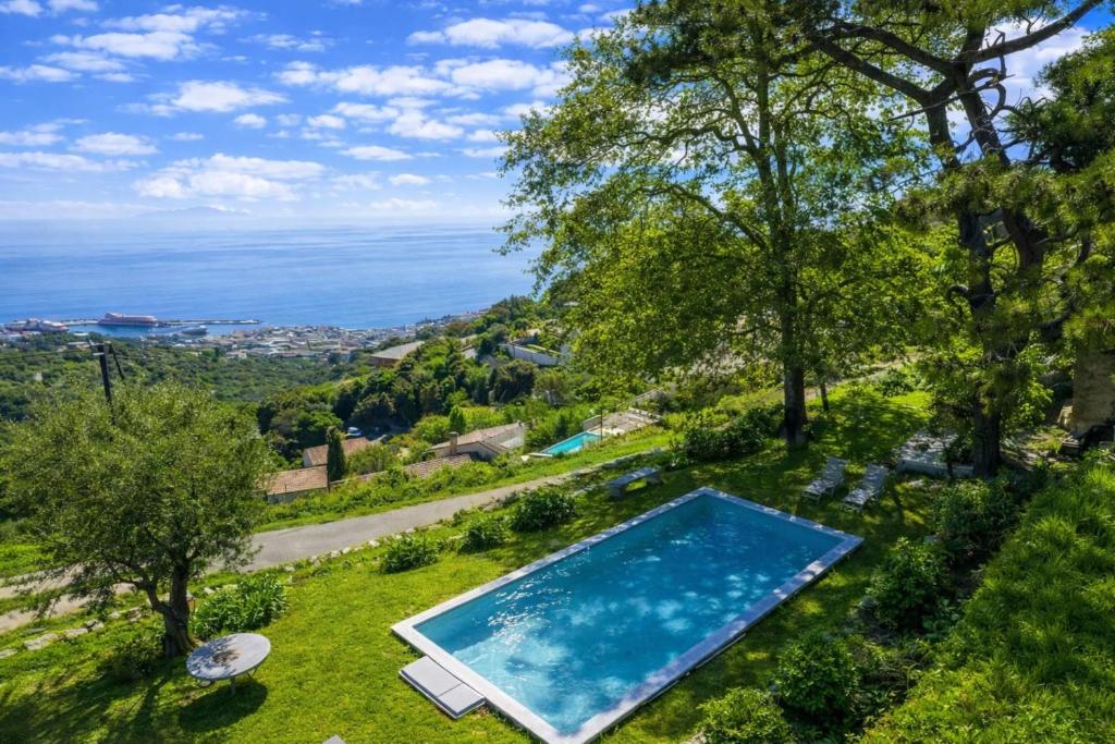 an outdoor swimming pool with a view of the ocean at Villa A Ventosa in Bastia
