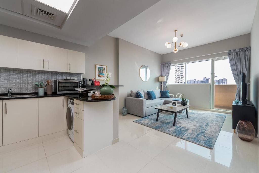 a kitchen and living room with a couch and a table at Urban Chic - Marina Bay in Abu Dhabi