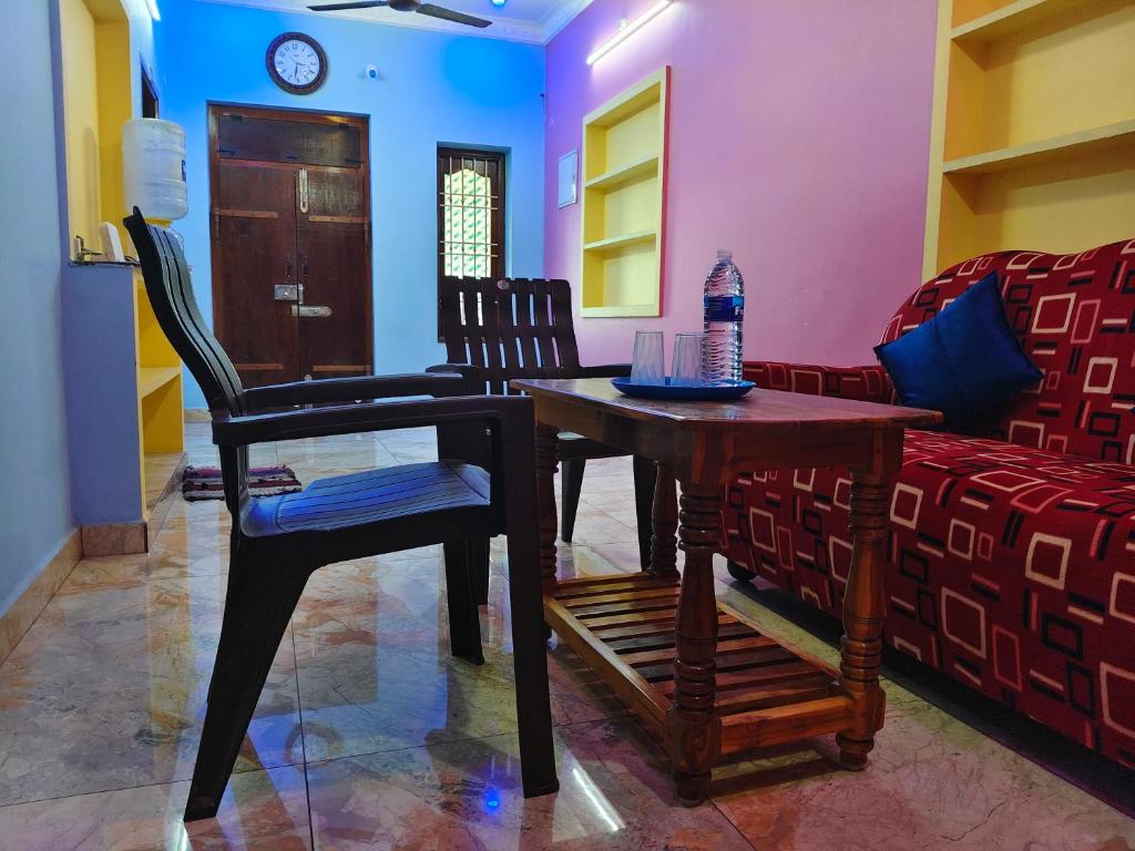 a living room with a table and chairs and a couch at Ocean Wind Homestay in Pondicherry