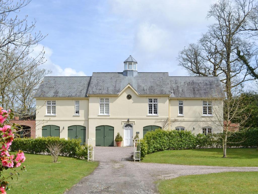 a large white house with green doors at Garden Cottage in Westleigh