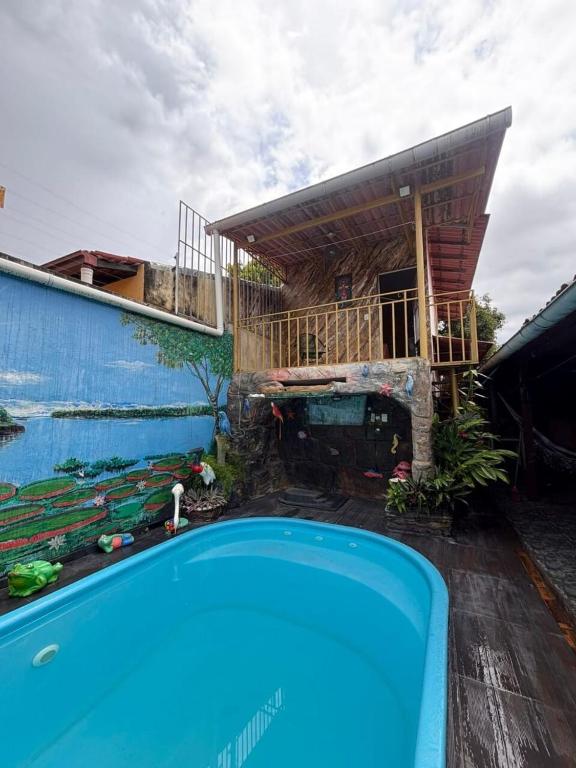 a house with a blue swimming pool in front of it at Chalé Santarém, located in Mosqueiro! in Belém