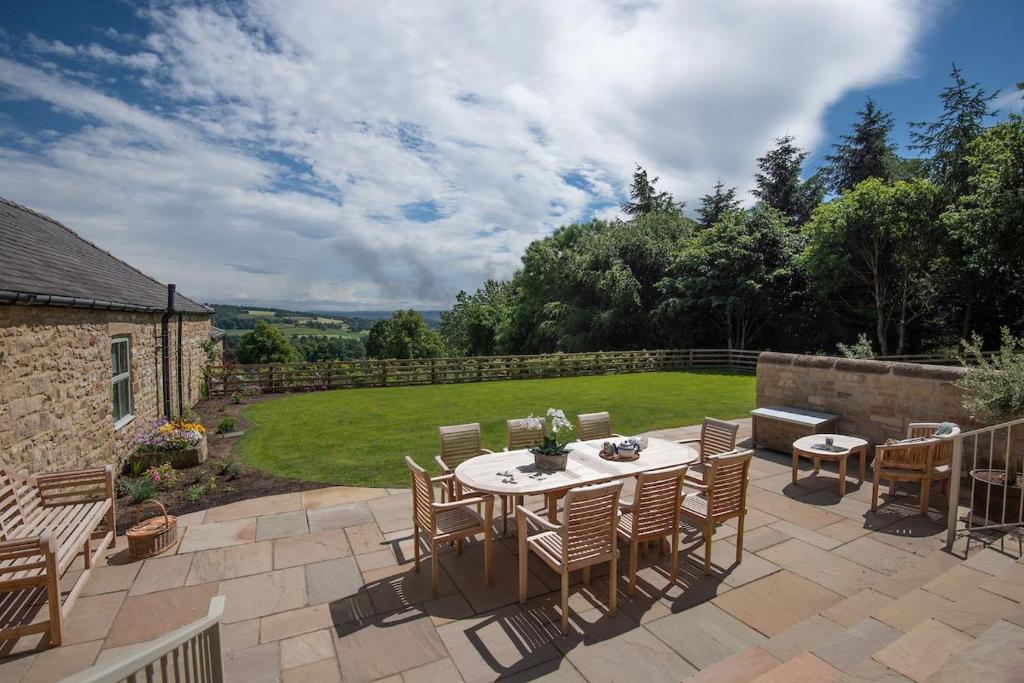 a patio with a table and chairs in a yard at Old Granary House in Chesters