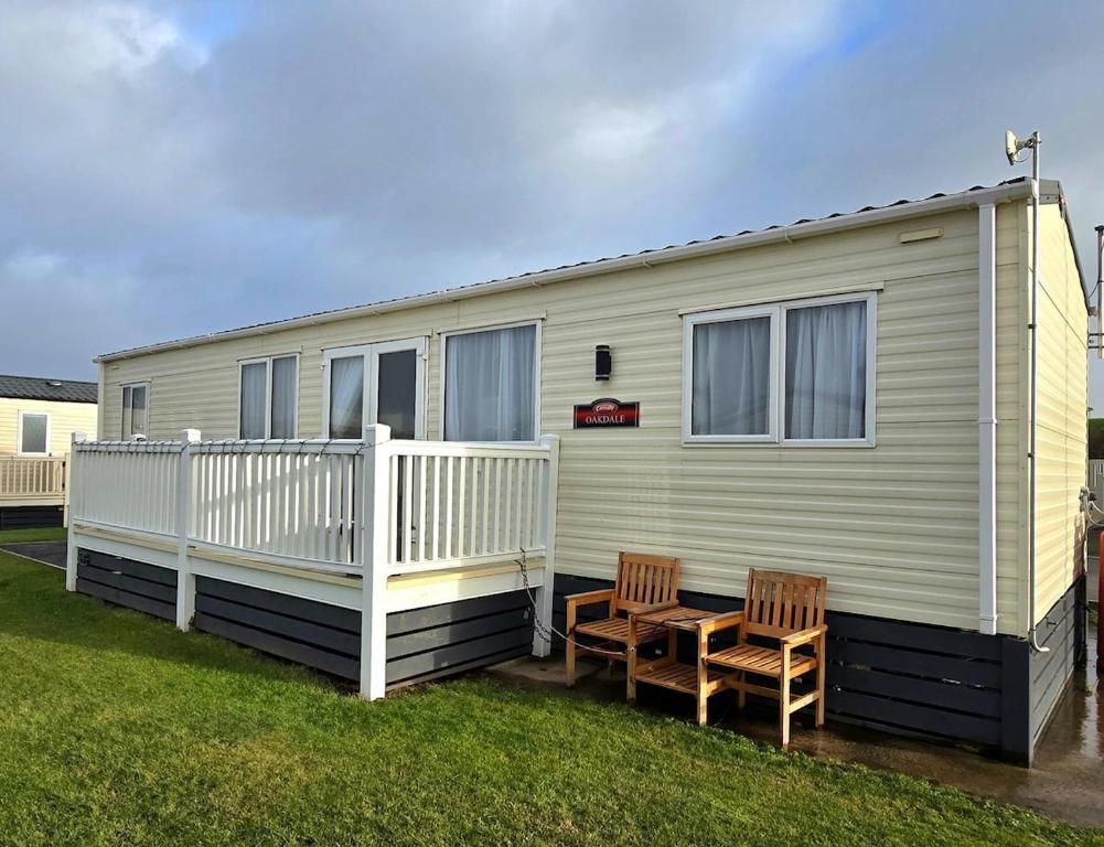 a mobile home with two chairs and a porch at CJ's Happy Place in Heysham
