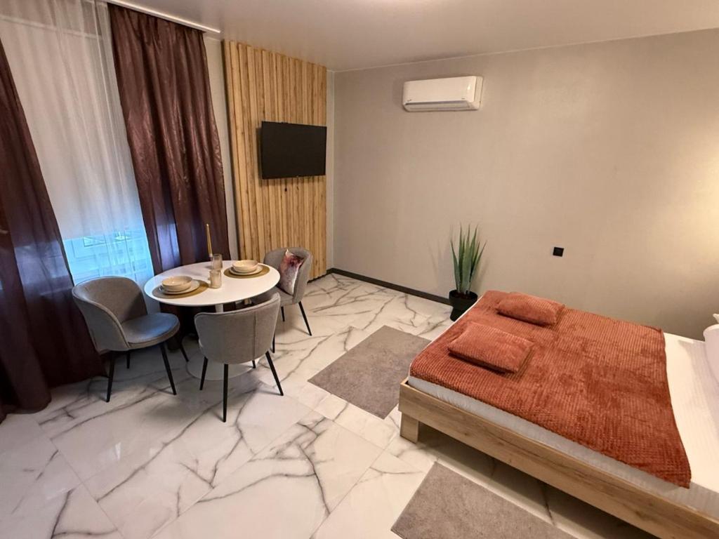 a bedroom with a bed and a table and chairs at Urban Nest in Truskavets