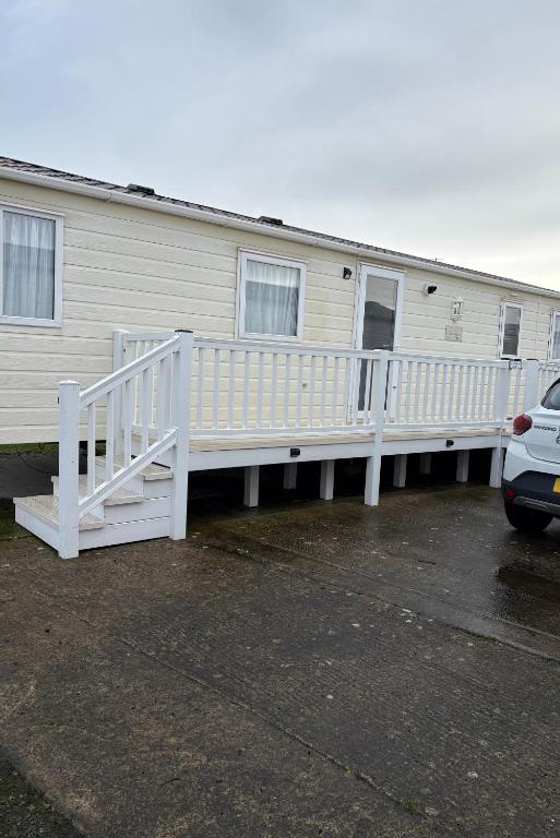 a house with a white ramp next to a parking lot at Sleeps 8 guests lovely 3 Bedroom Golden Gate Towyn in Llanddulas