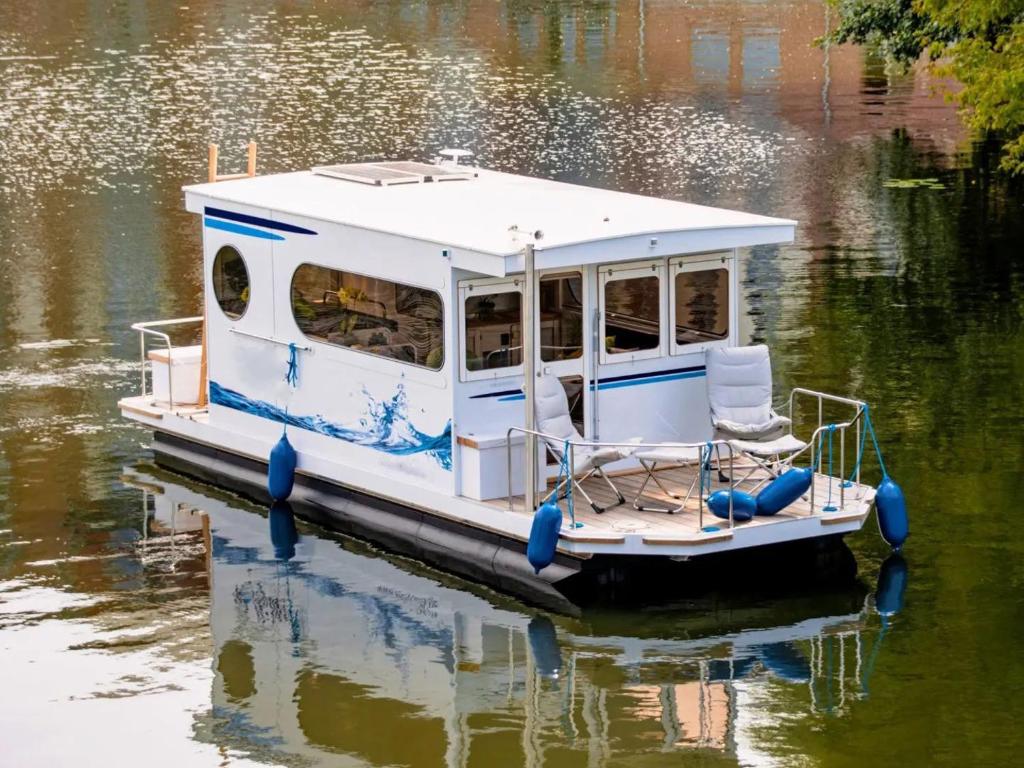 a blue and white boat floating on the water at Neues Hausboot für 4 Personen Müritz und Plauer See in Lübz