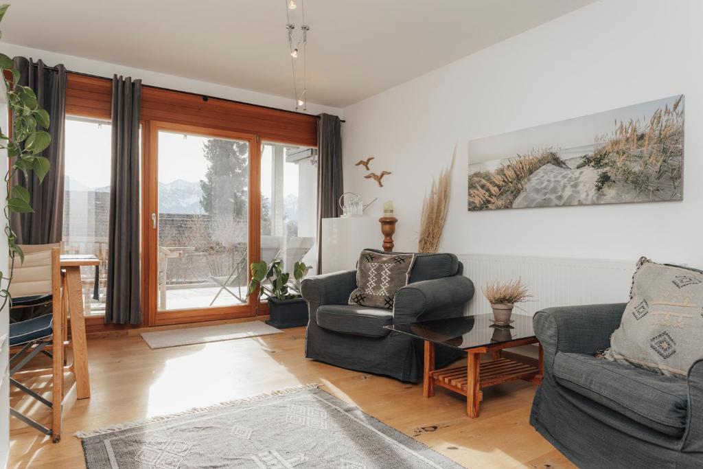a living room with two chairs and a table at Stilvoll und ruhig in Füssen