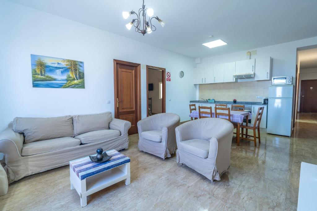 a living room with a couch and chairs and a kitchen at Edificio Prieto VIV 2C in Puerto del Rosario