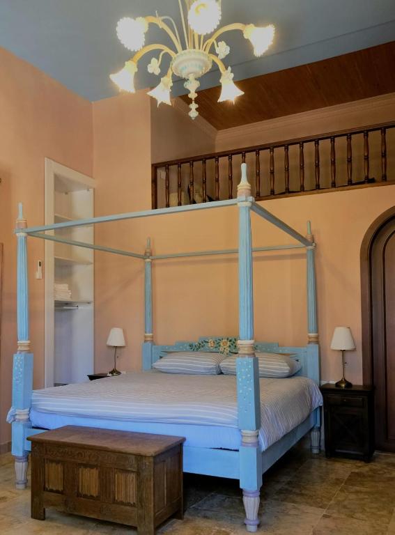 a bedroom with a blue canopy bed and a table at Spiritu in Ḩārat al Qal‘ah