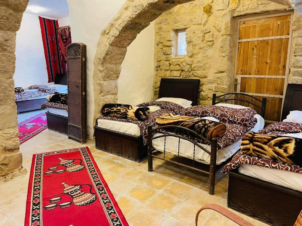 a room with four beds and a stone wall at Night in Dana in Dana
