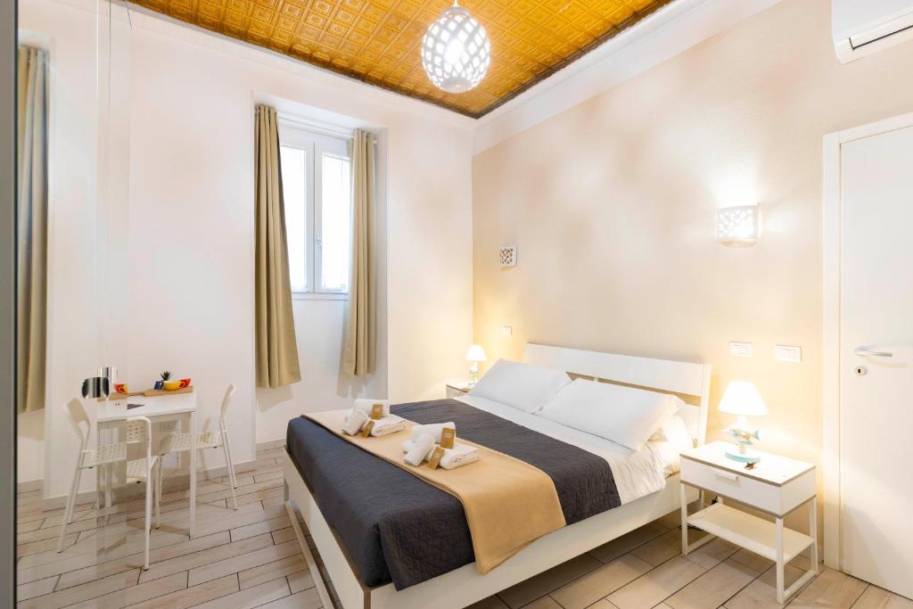 a bedroom with a bed and a table and a desk at Approdo Rooms - Eja Sardinia in Cagliari