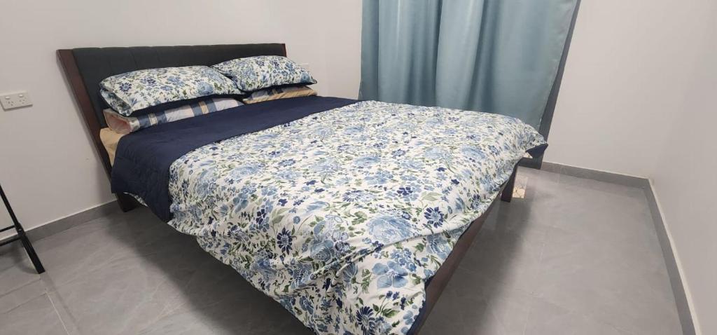a bed with a blue and white comforter and pillows at Capital Transit Hub in Port Moresby