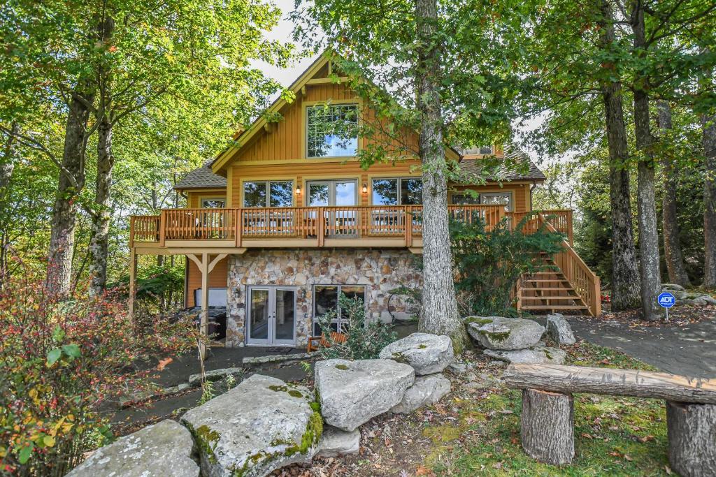 a log cabin in the woods with a deck at Alpine Adventure in McHenry