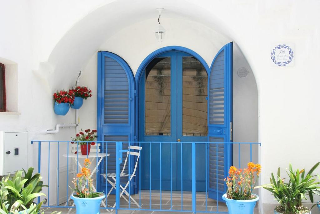 a blue door in a white building with plants at Janela Blue Civico 35 in Otranto
