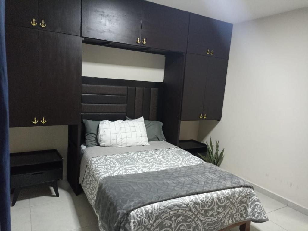 a bedroom with a bed and dark brown cabinets at Don Charlie in Veracruz