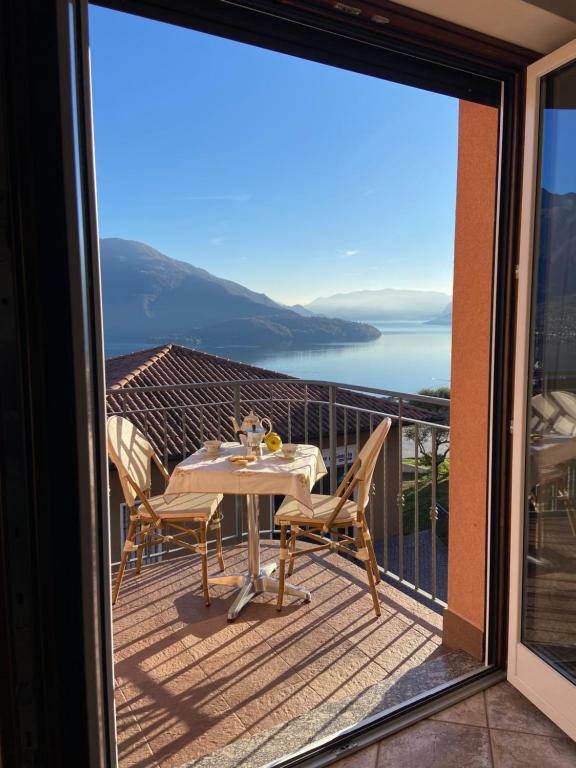 a table and chairs on a balcony with a view of the ocean at Appartamento sole in Vercana