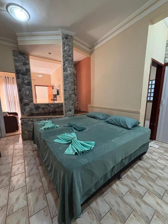 a bedroom with a large bed with green sheets at Sereny Stone Palace in Rondonópolis