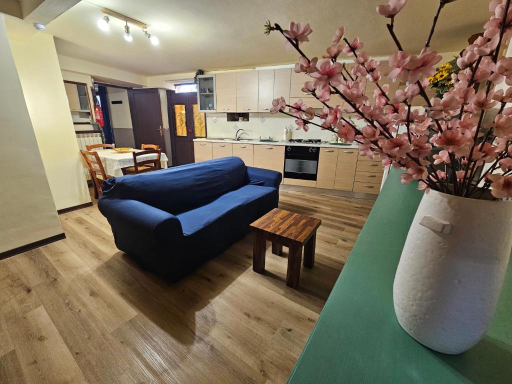 a living room with a blue couch and a vase with flowers at Locazione Turistica LBS, San Giacomo , Spoleto in San Giacomo