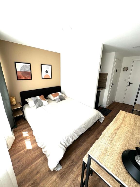 a bedroom with a large white bed in it at L'Emile Zola 2 in Saint-Quentin