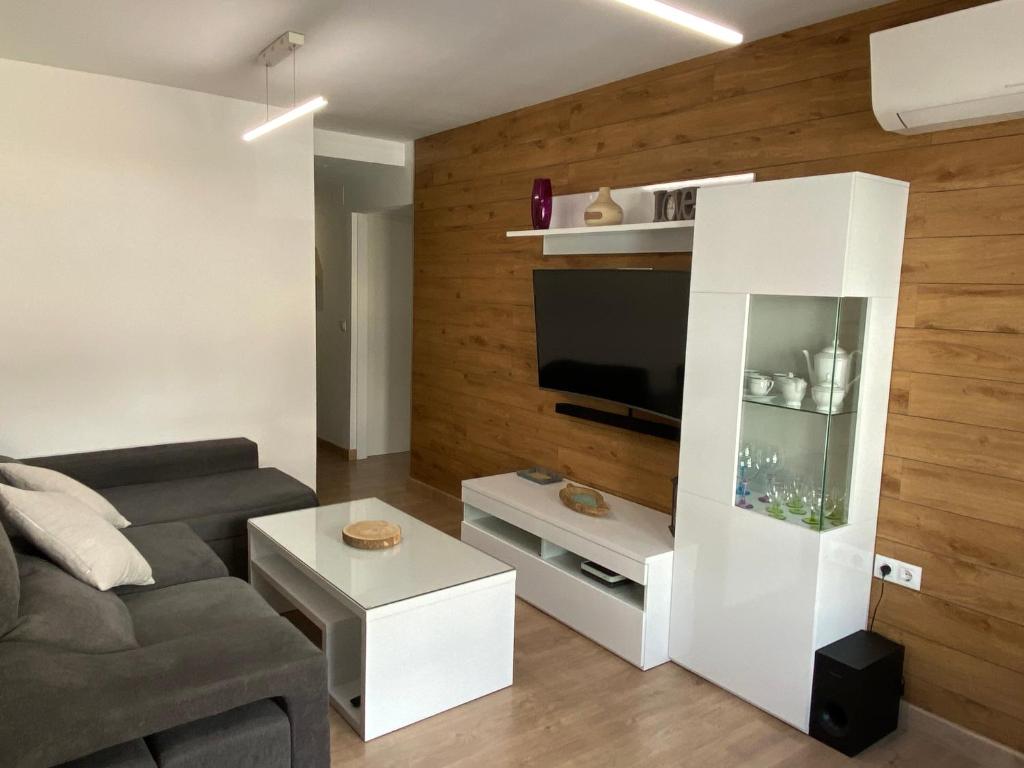 a living room with a couch and a tv at Alameda in Pinos Genil