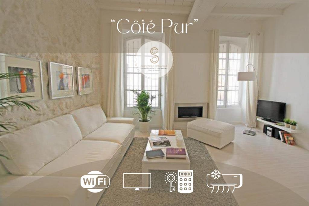 a living room with a white couch and a coffee table at Côté Pur Arles Centre in Arles