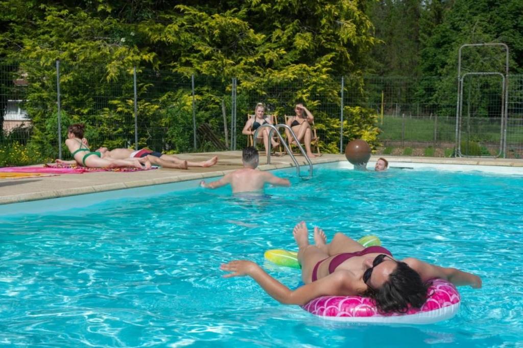 a group of people in a swimming pool at Camping nature 3 étoiles - au coeur des montagnes du Jura in Levier