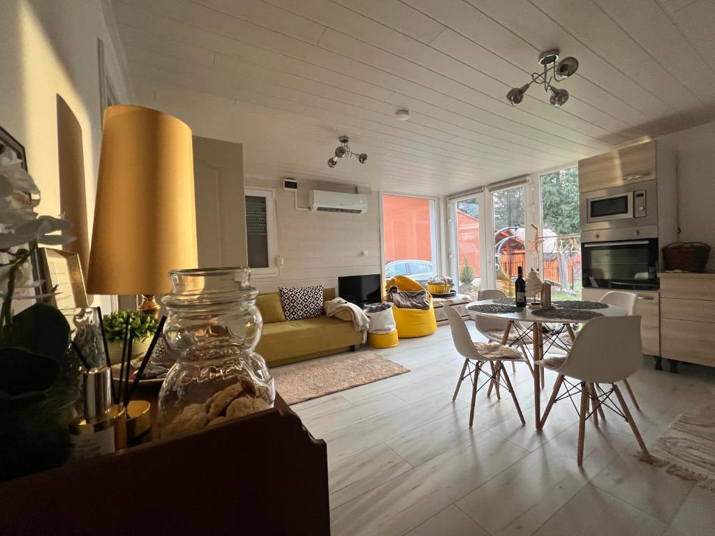 a kitchen and living room with a table and chairs at Gold Frog Apartman in Abaliget