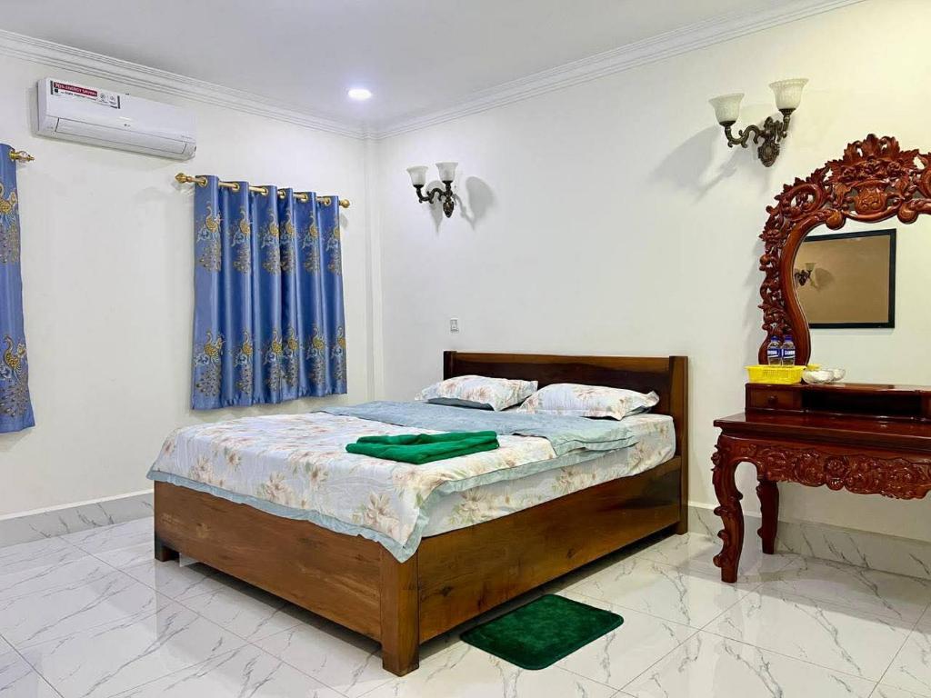 a bedroom with a bed and a mirror and a piano at Lamoure' Maison Hostel & Suite in Battambang