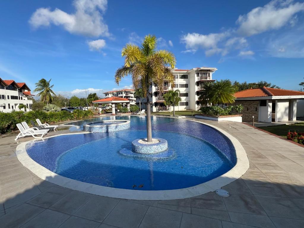 a large pool with a palm tree in the middle at Brisas Vista Serena in Nueva Gorgona