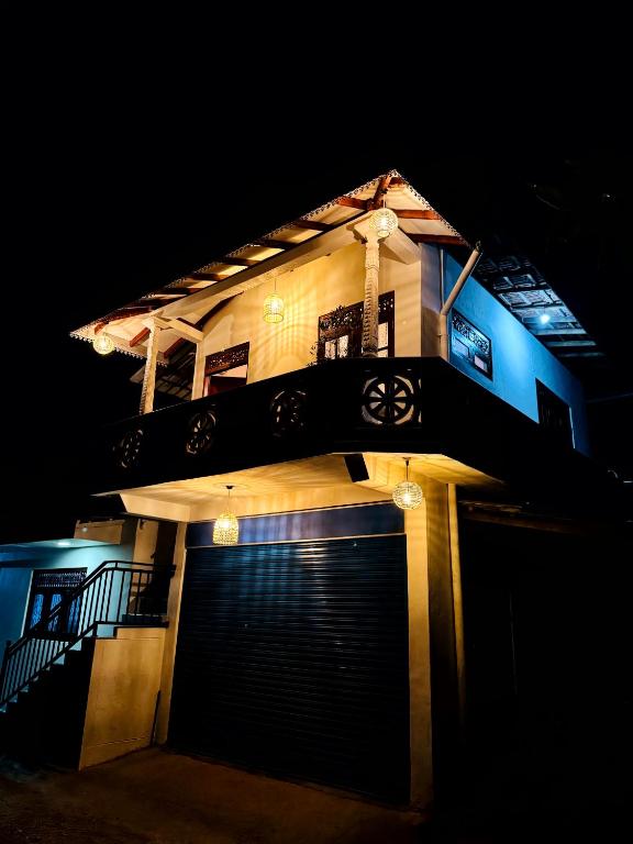 a house with a gate and a garage at night at Diddi's in Weligama