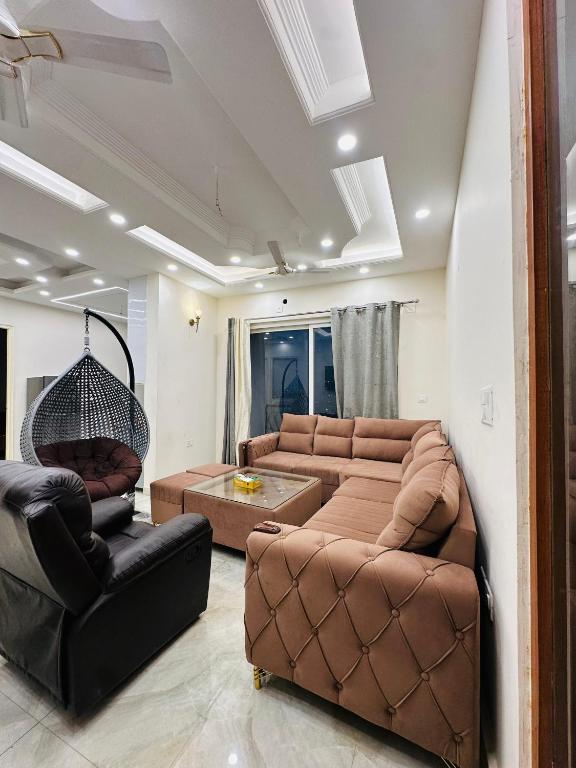 a living room with two couches and a table at Dream heaven in Greater Noida