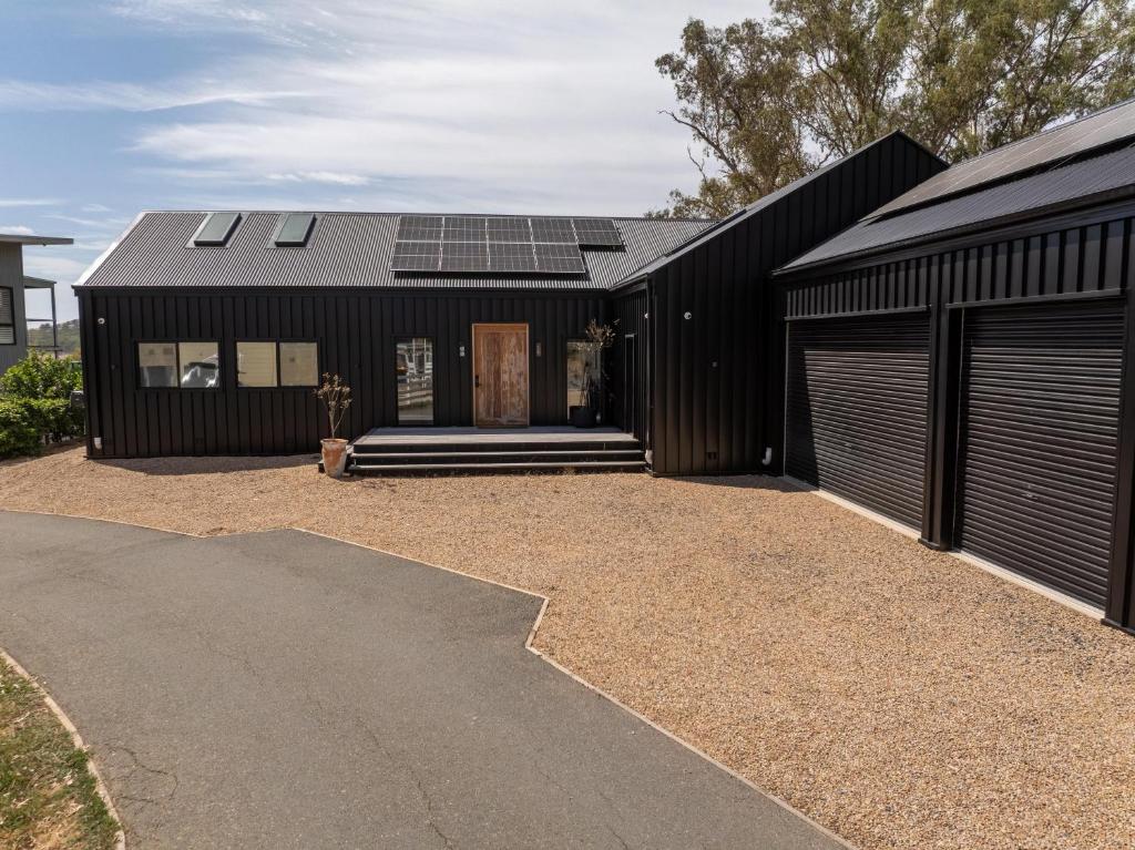 a black house with solar panels on the roof at The Barn Bonnie Doon in Bonnie Doon