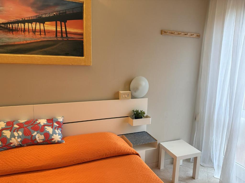 a bedroom with a bed and a painting of a pier at Hotel Picador in Rimini