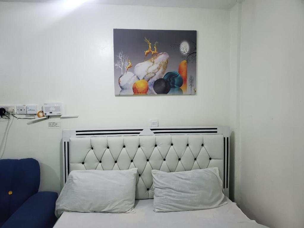 a bedroom with a bed and a picture of fruit at Velour Spacious Suites in Rungiri