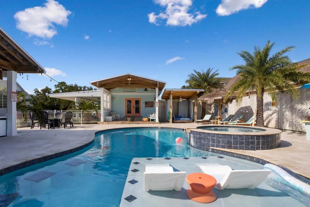 a swimming pool with a resort style house at Suite Flamingo Pointe with Shared POOL in Bay Saint Louis